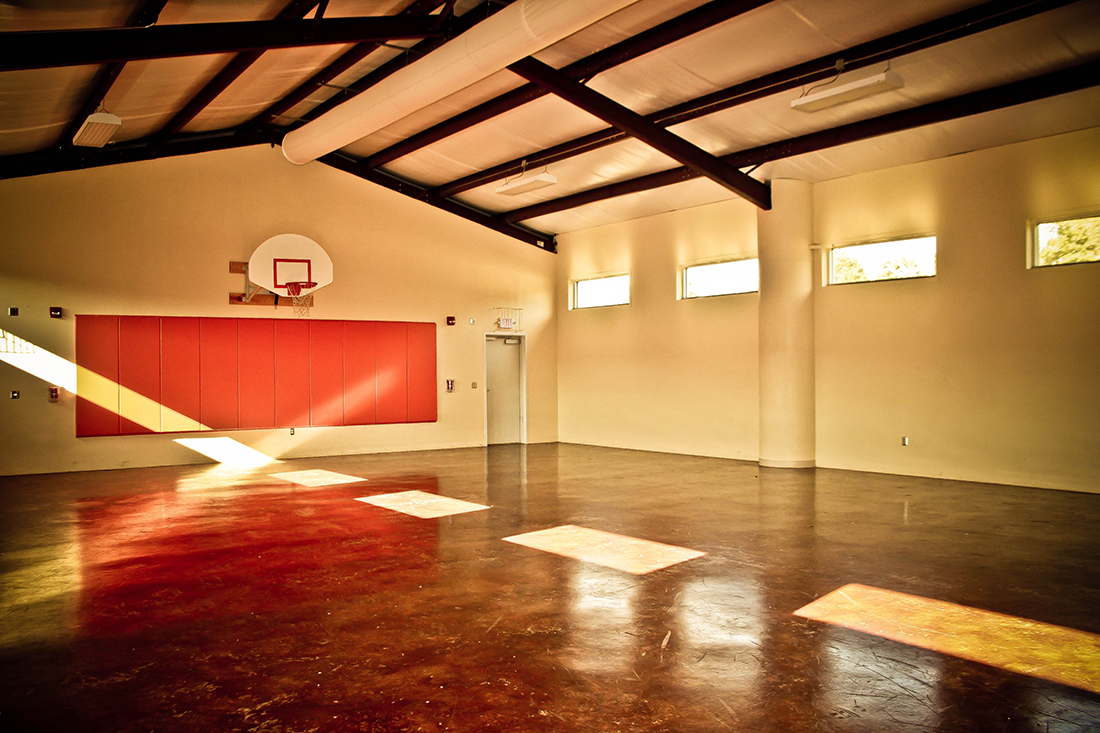 Indoor recreation gym with basketball hoop and open floor space