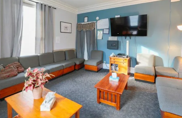 Cozy lounge with gray sofas, wood tables, and wall-mounted TV