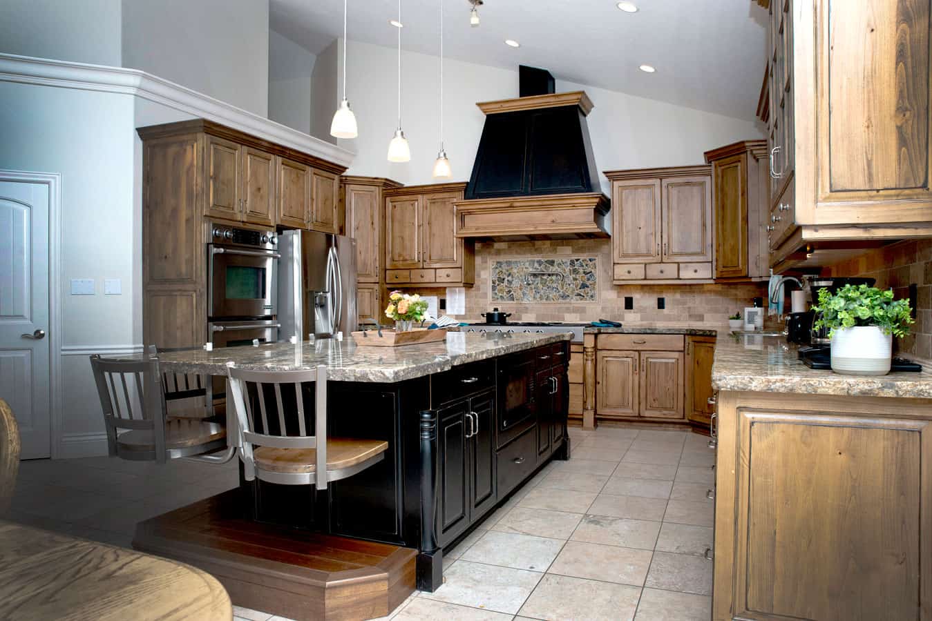 Large gourmet kitchen with island seating and wood cabinetry.