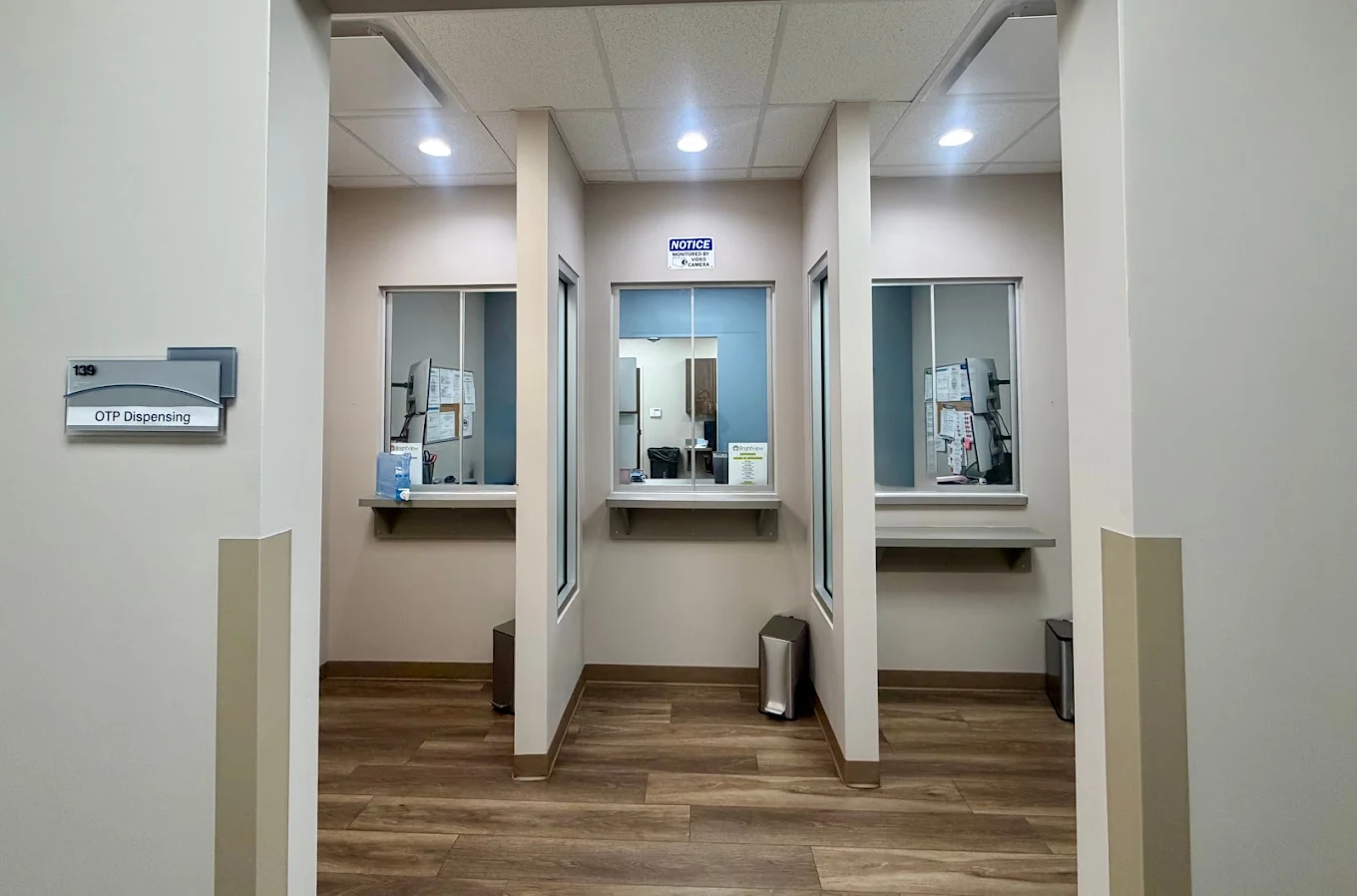 Medication dispensing area with three service windows, privacy partitions, counters, and an OTP Dispensing room sign