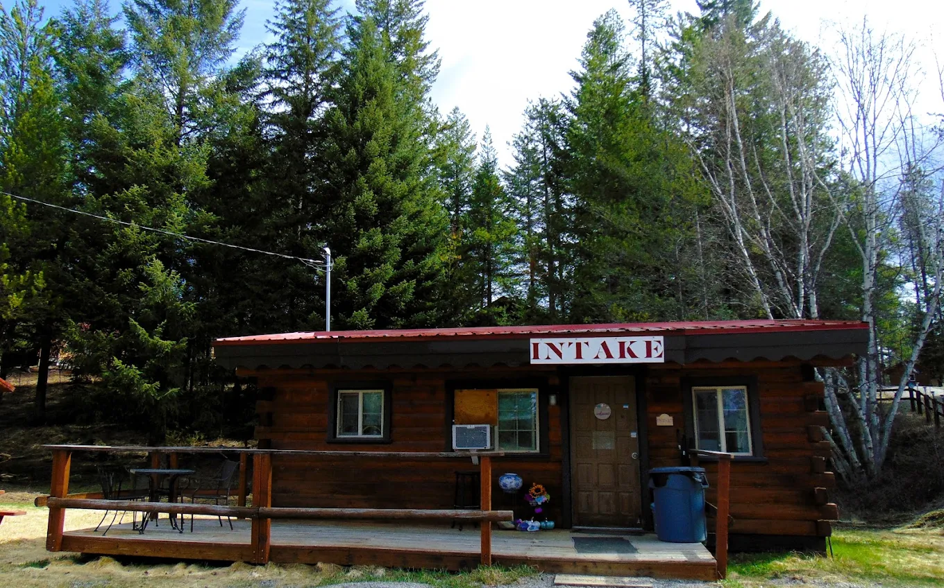 Log cabin intake building with a covered porch at Recovery Centers of Montana in Columbia Falls