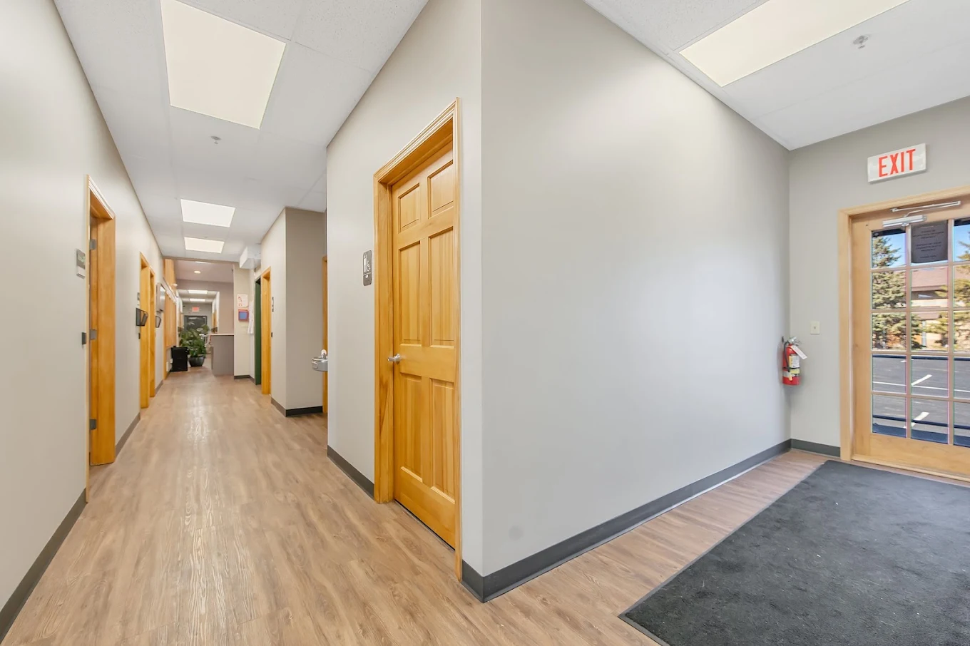Bright hallway with wood doors leading to treatment rooms