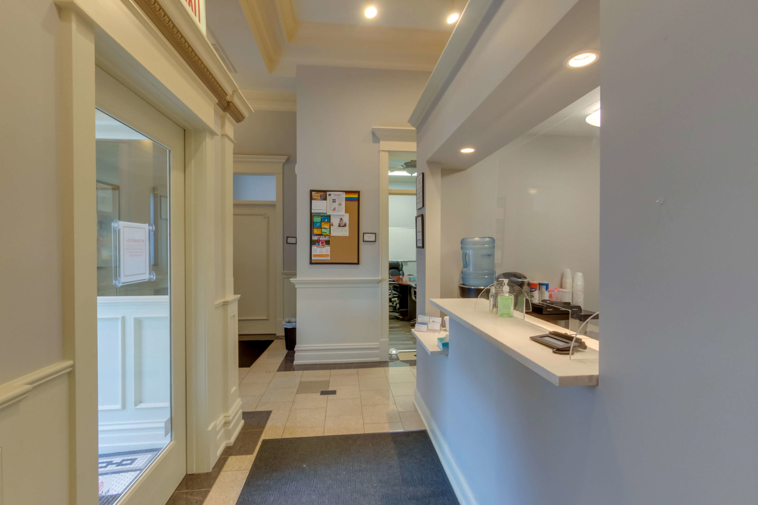 Hallway with reception desk and bulletin board.