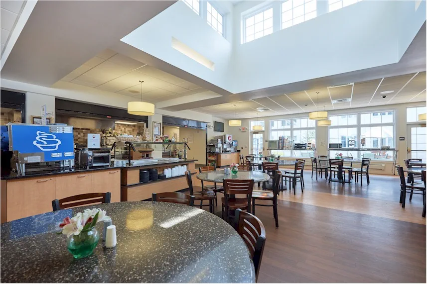 Bright dining area with tables and food service station.