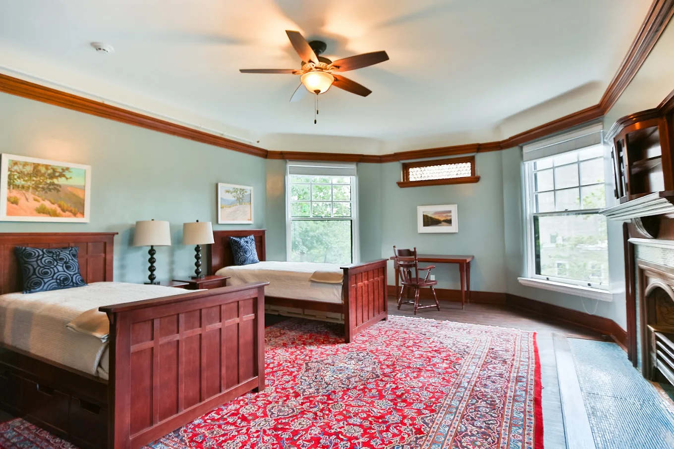 Shared bedroom with two beds, fireplace, and large windows