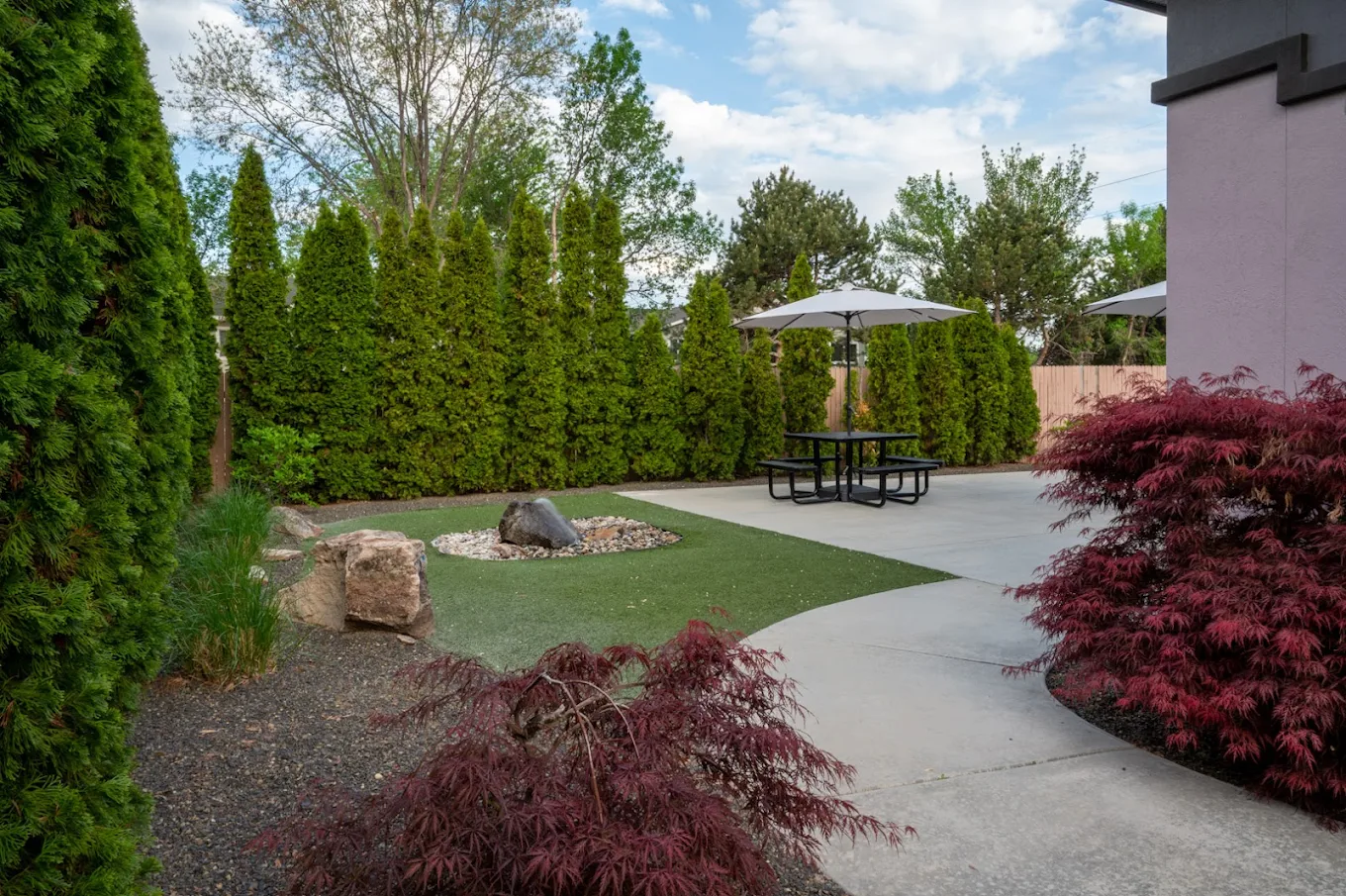 Landscaped patio with seating and shaded picnic table