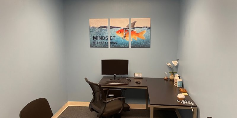  A cozy office space featuring a computer desk, chairs, motivational artwork with the message "Mindset is everything," and minimalist decor for focus.