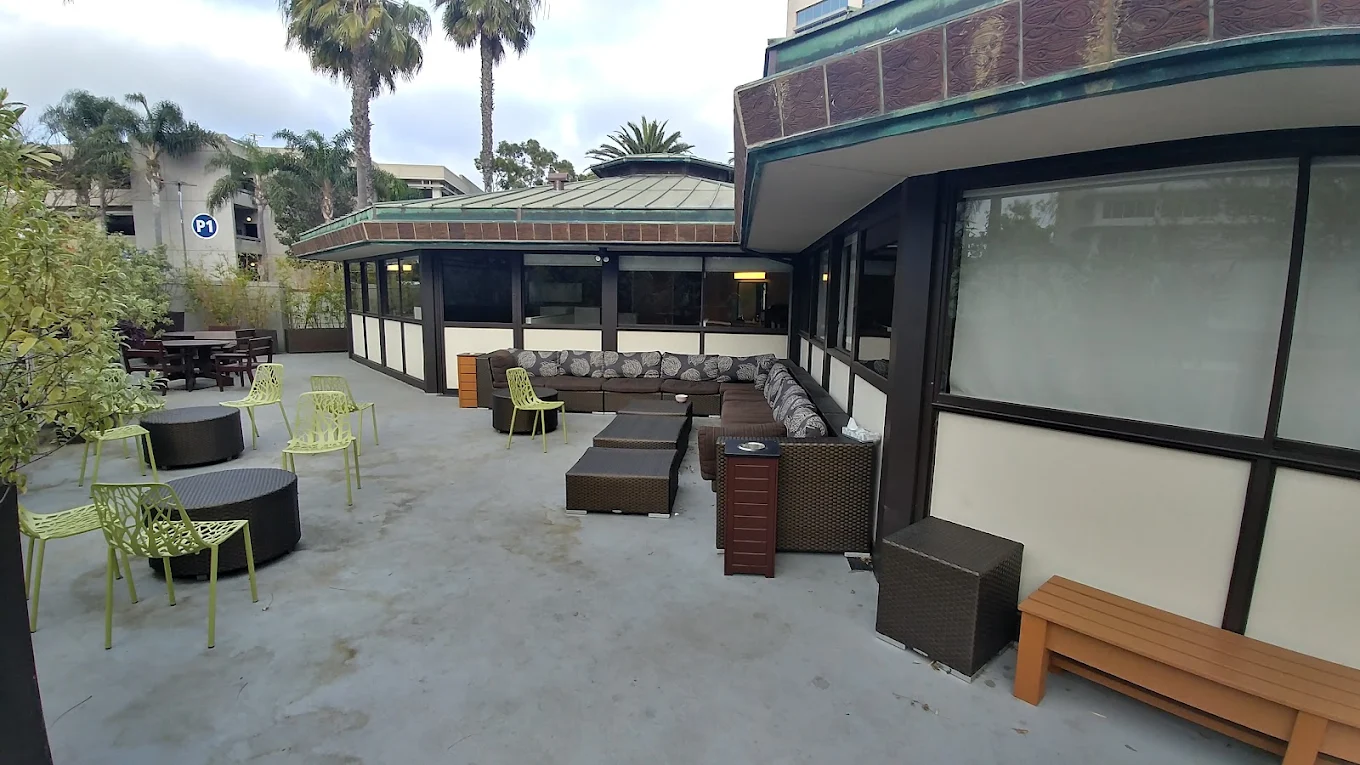 Outdoor patio with seating area and palm trees at facility