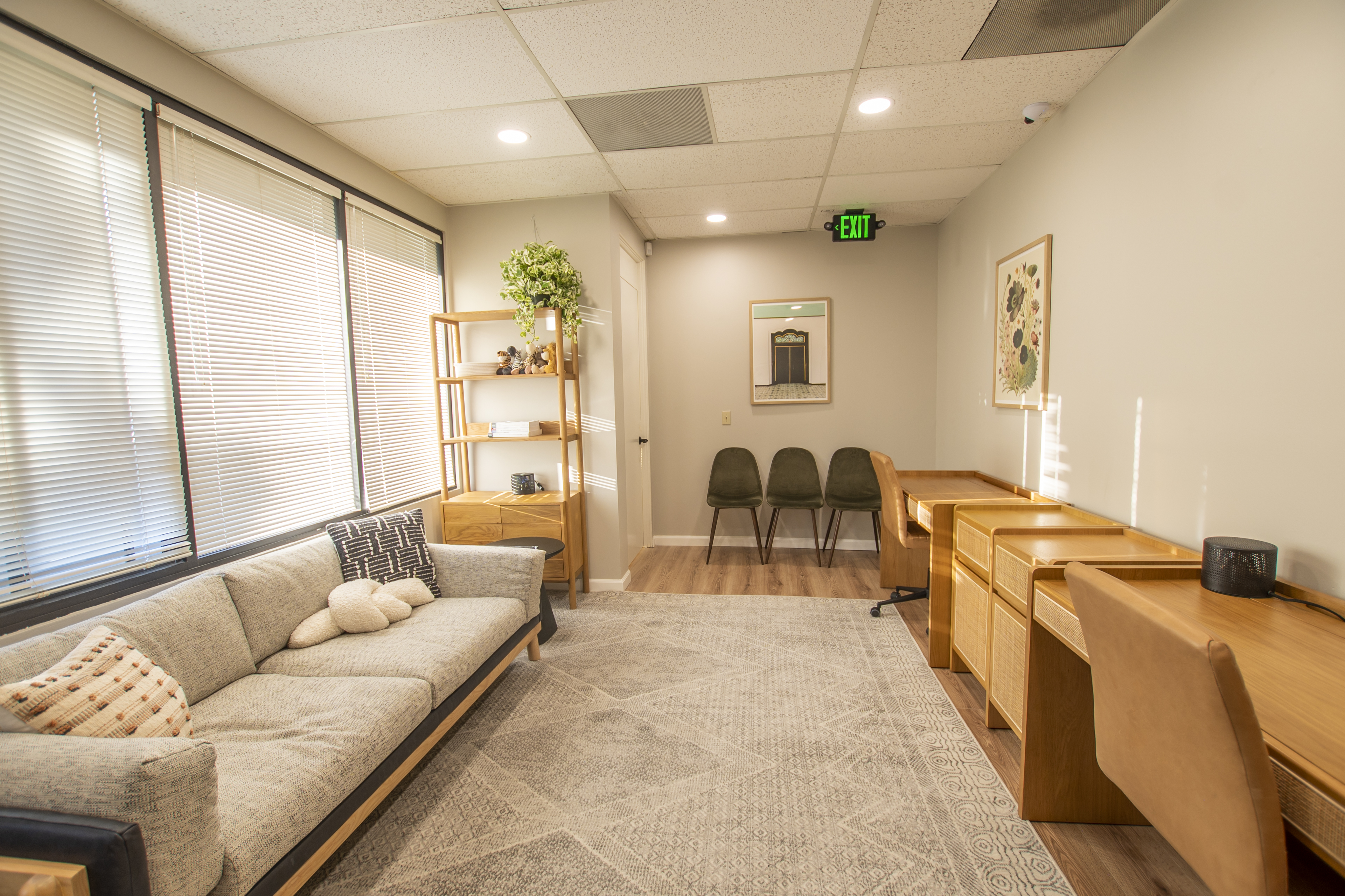 Lounge area with couch, desks, and open shelving