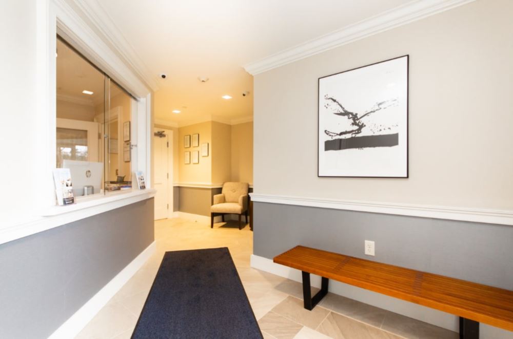 Lobby with  chairs, reception desk window.