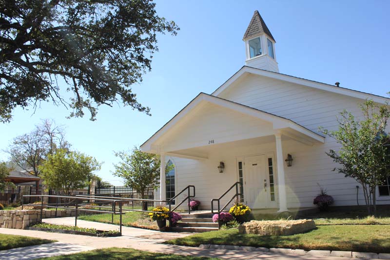 Serenity Chapel white building with steeple and landscaping