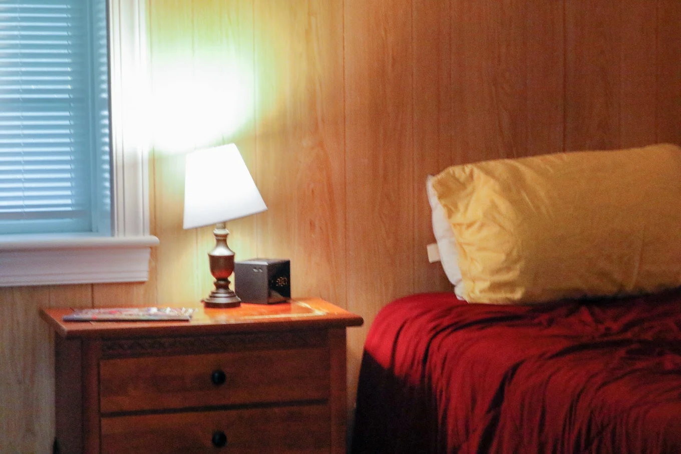 Private bedroom with bedside table and lamp at Hope Valley Treatment