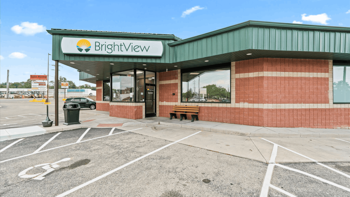 Exterior entrance of BrightView Health Dayton with large BrightView sign, brick facade, bench, and accessible parking spaces