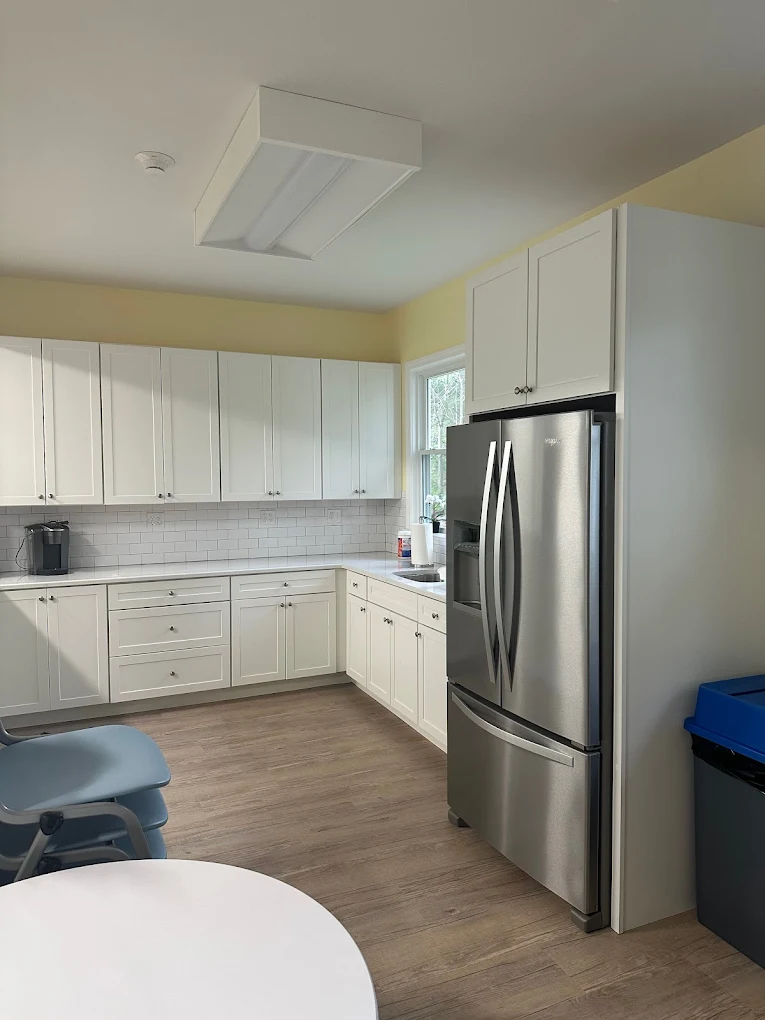 Bright kitchen with white cabinets and stainless refrigerator