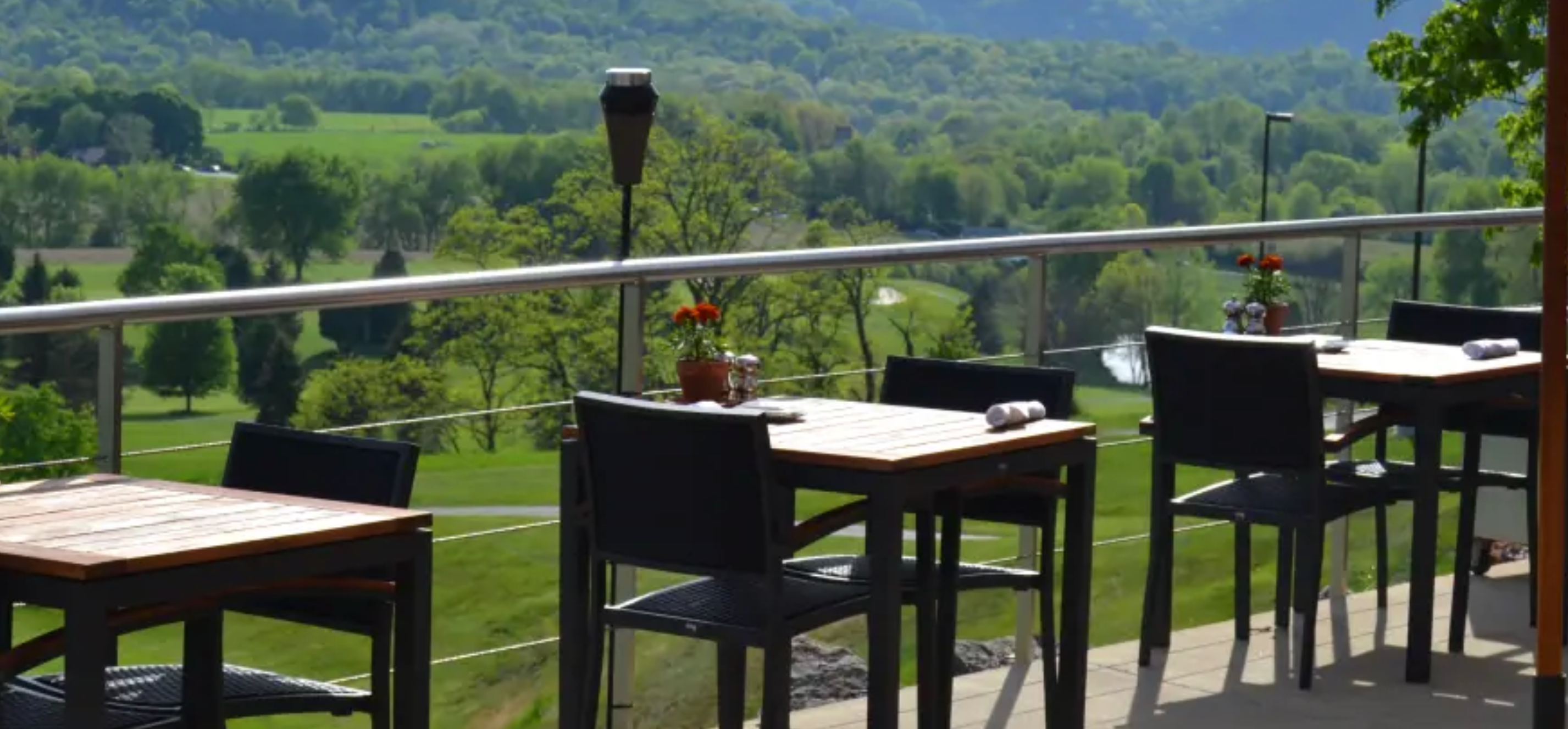 Patio seating overlooking scenic green landscape.