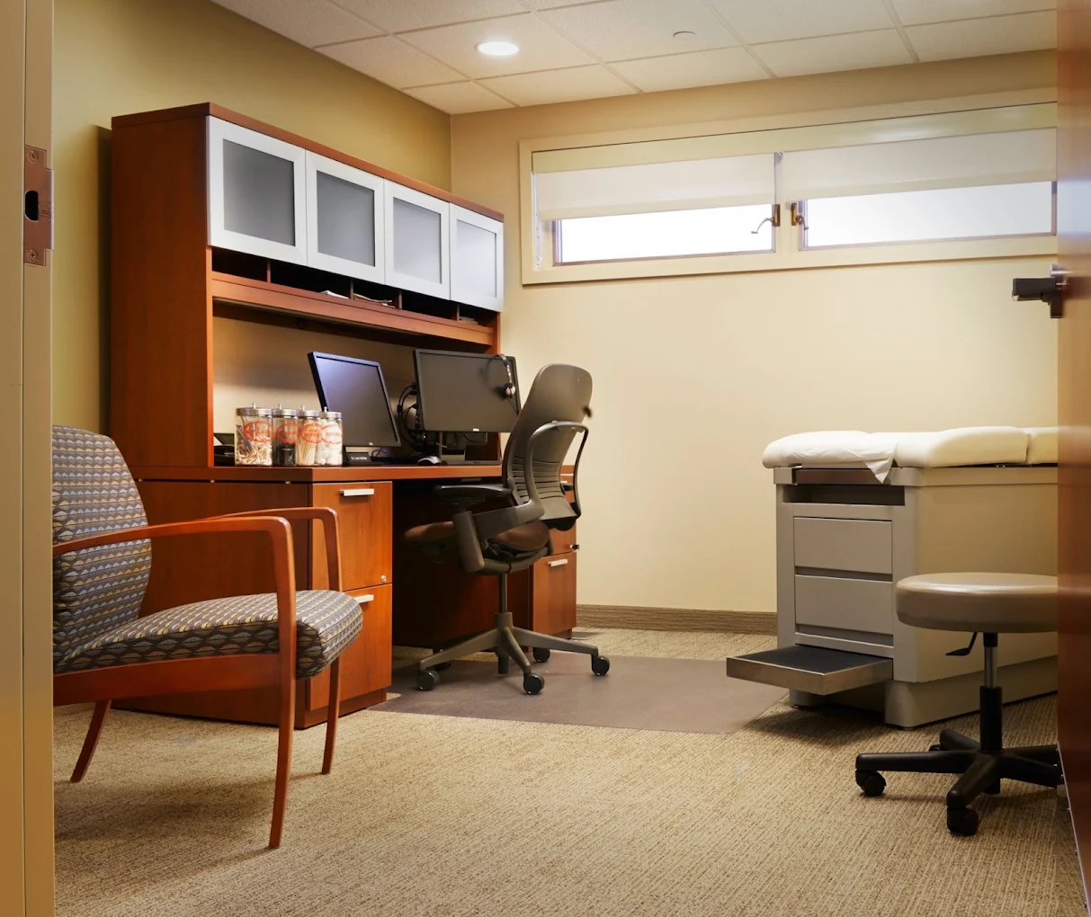 Private exam room with medical exam table, workstation, and guest chair