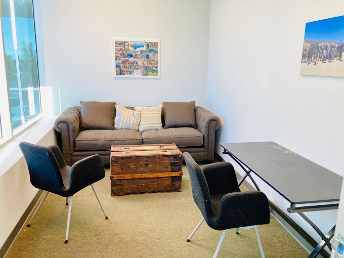 Cozy therapy room with a sofa and chairs, offering a private and calming space for individual counseling sessions.