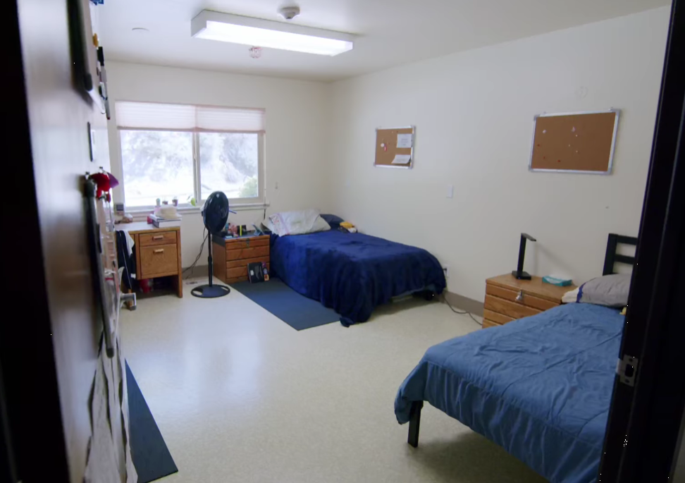 Bright shared bedroom with two beds and wooden furniture