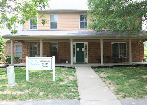 Brick building with green door and Family Ark sign out front