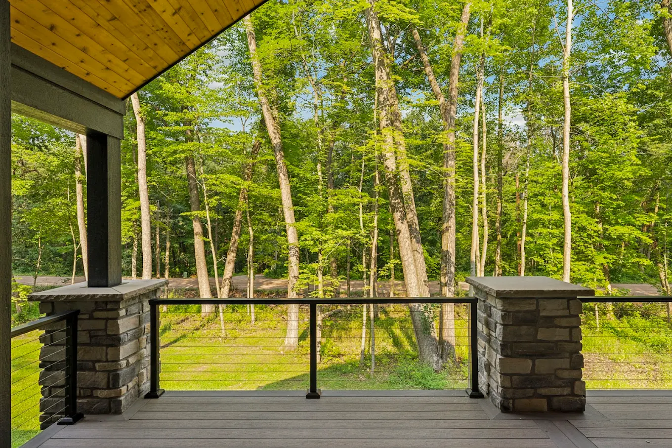 Covered deck overlooking forested landscape