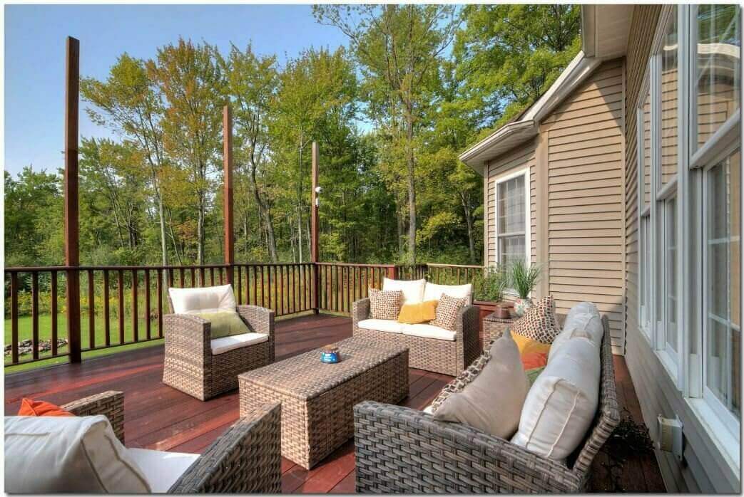 Outdoor seating area with sofas on wood deck by trees