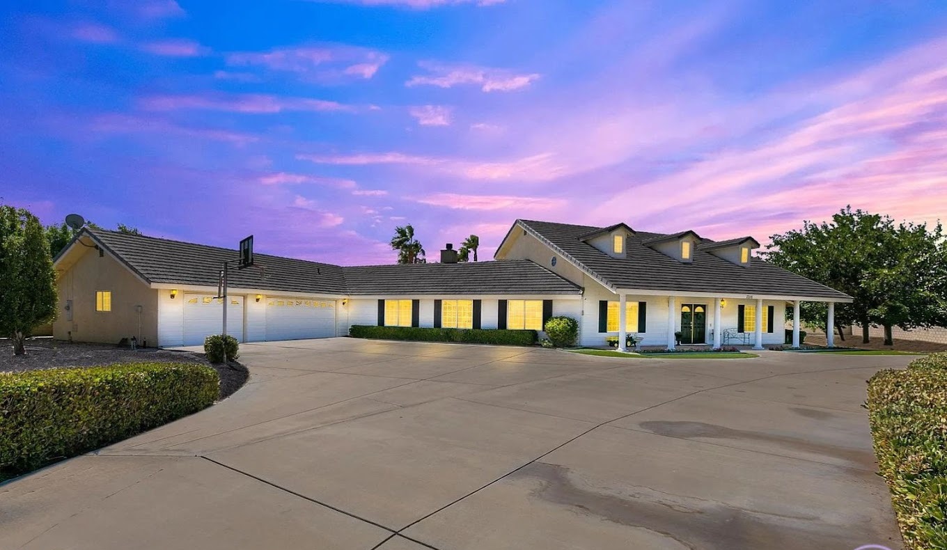 Large home-style facility with wide driveway and lit windows