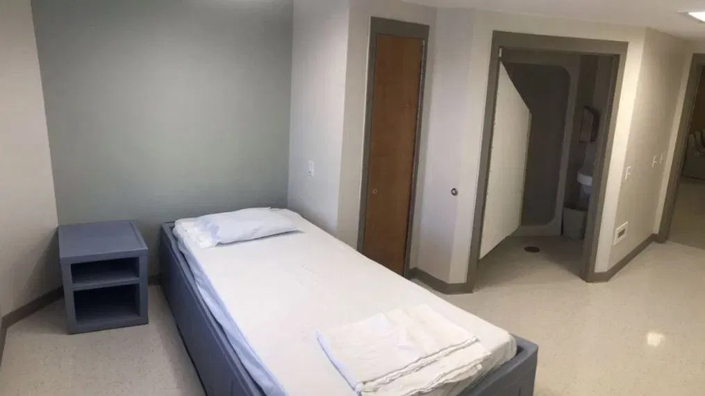 Basic hospital room with single bed and private restroom