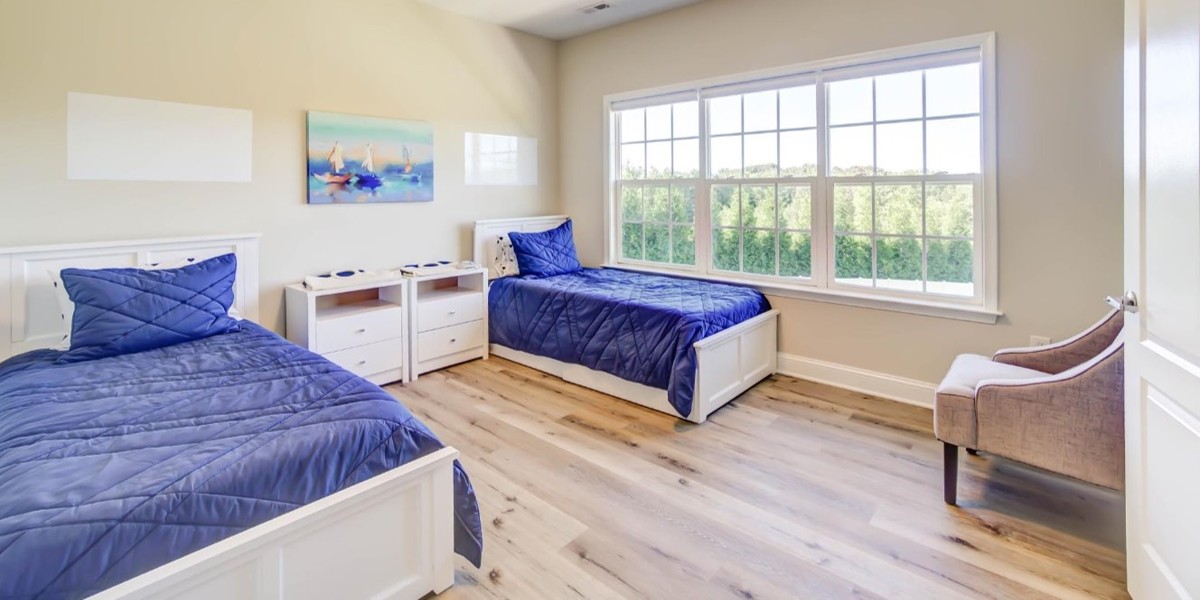 Twin bedroom with blue bedding and large window views
