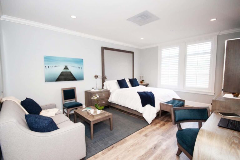 Private suite with bed, seating area, and workspace