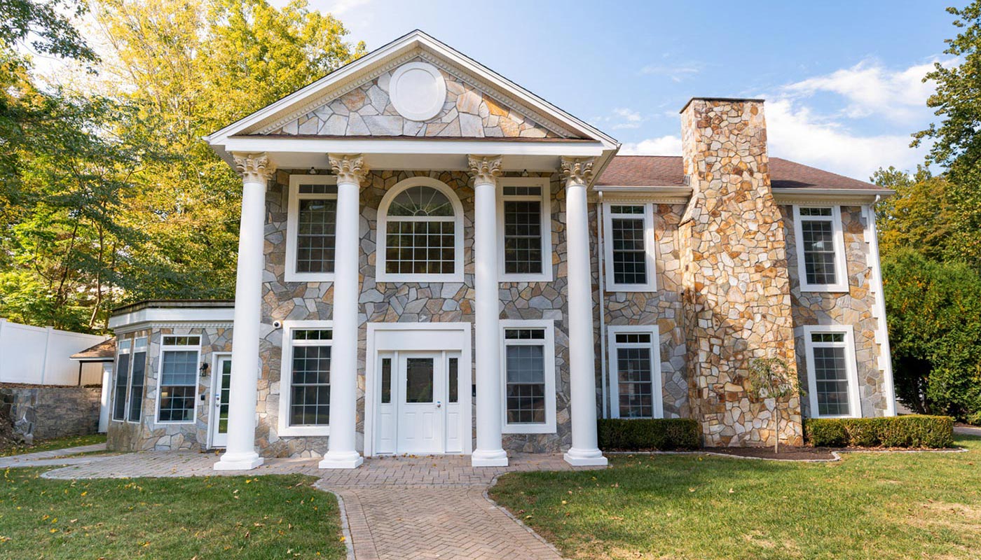 Stone-front building with tall white columns and large windows.