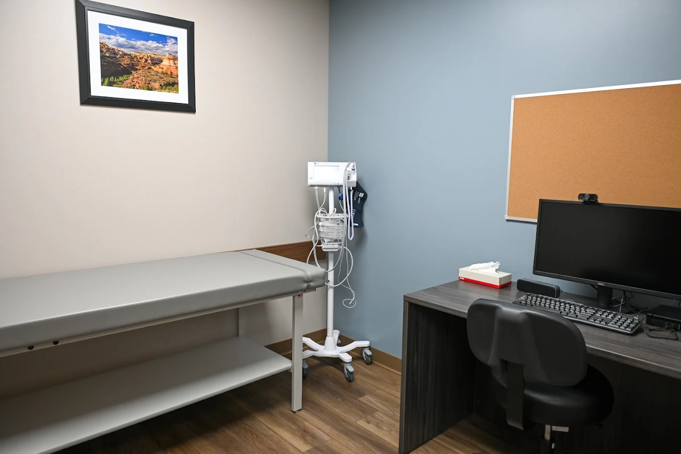 Medical exam room with exam table and workstation
