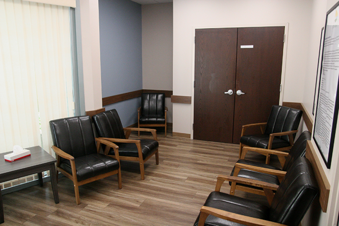 Group therapy room with black chairs arranged for meetings