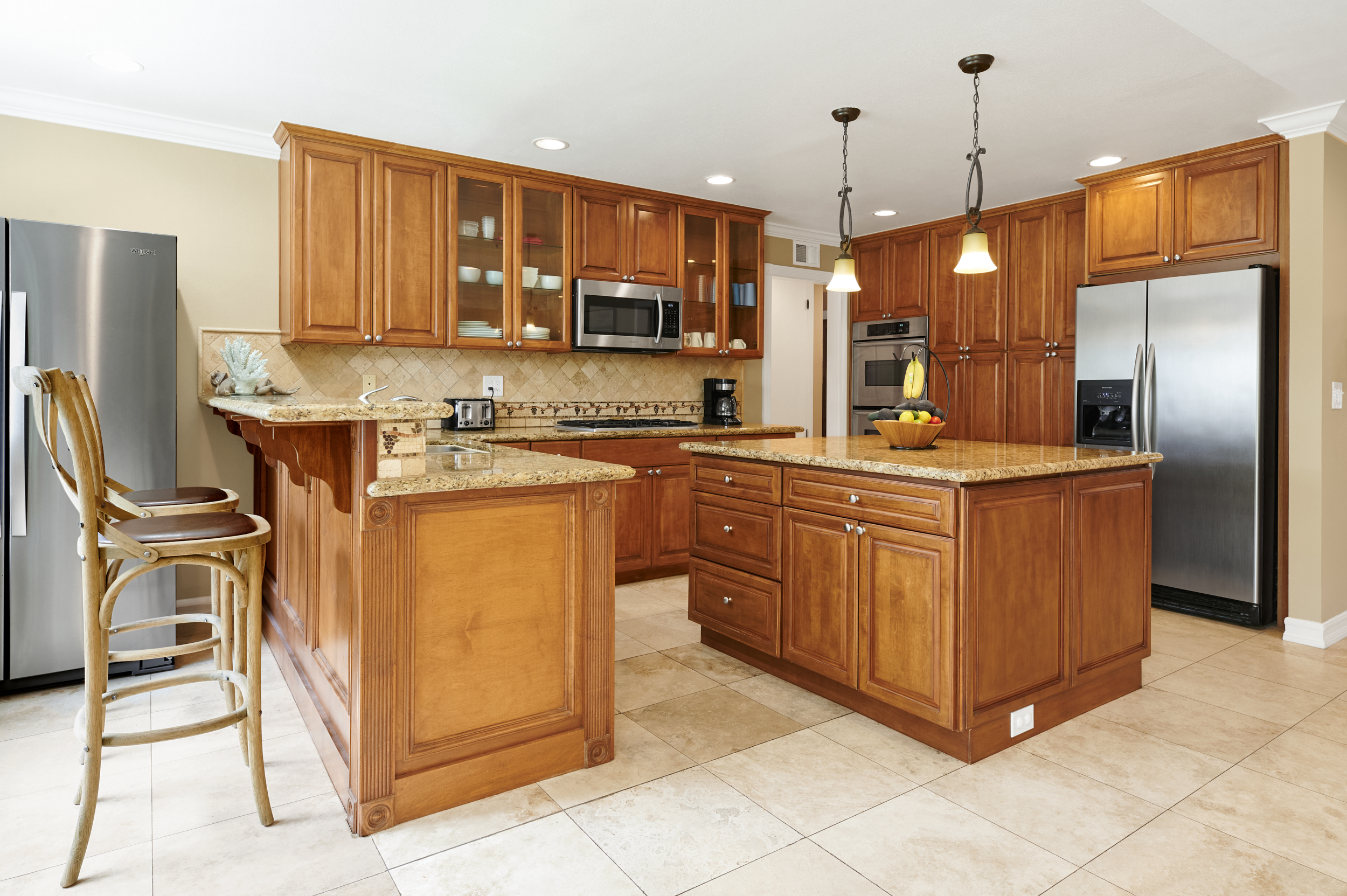 Kitchen with a center island, and bar stools.