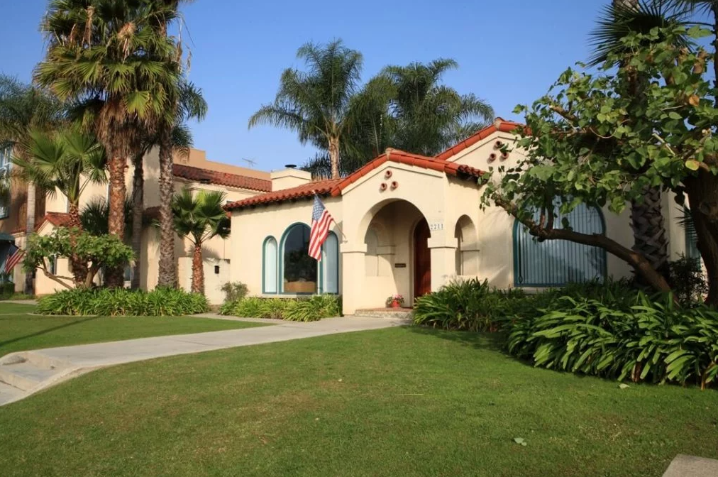 Spanish-style rehab center exterior with palm trees