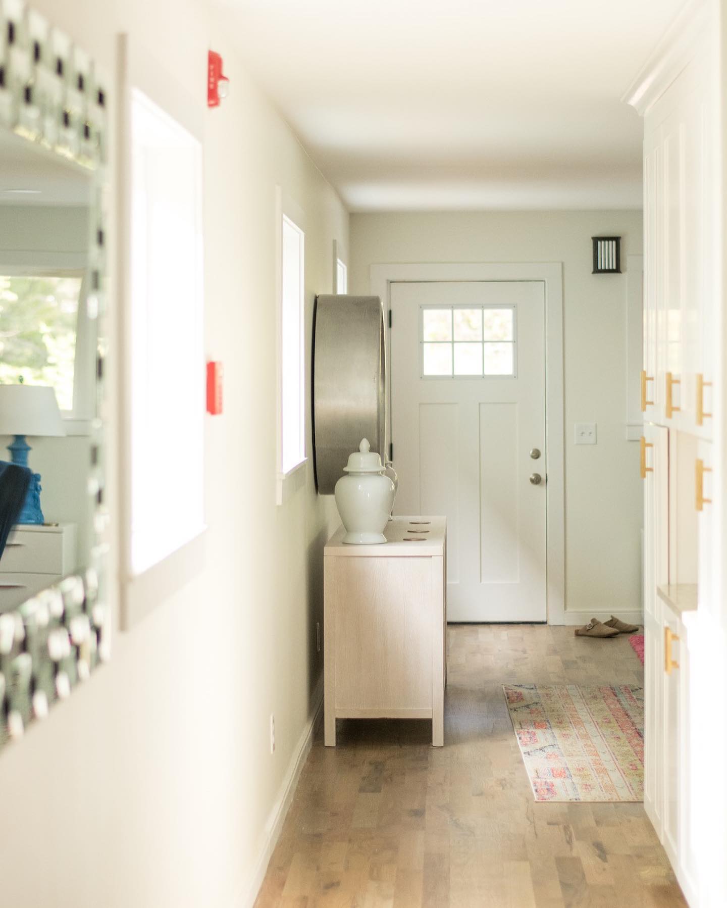 Bright hallway with wood floors and entry door