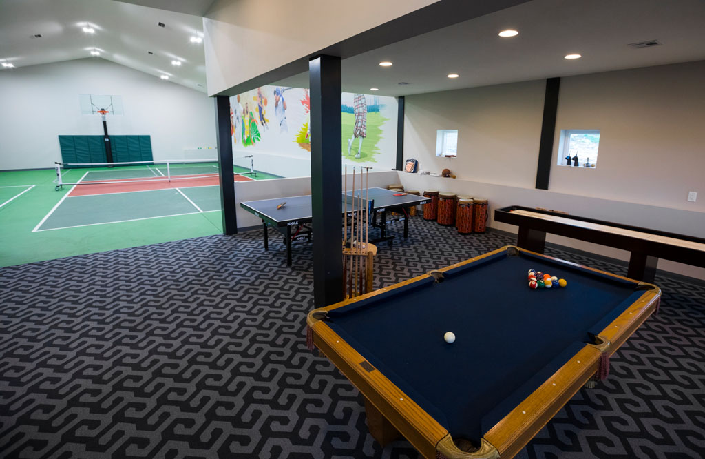 Indoor recreation area with basketball court and game tables
