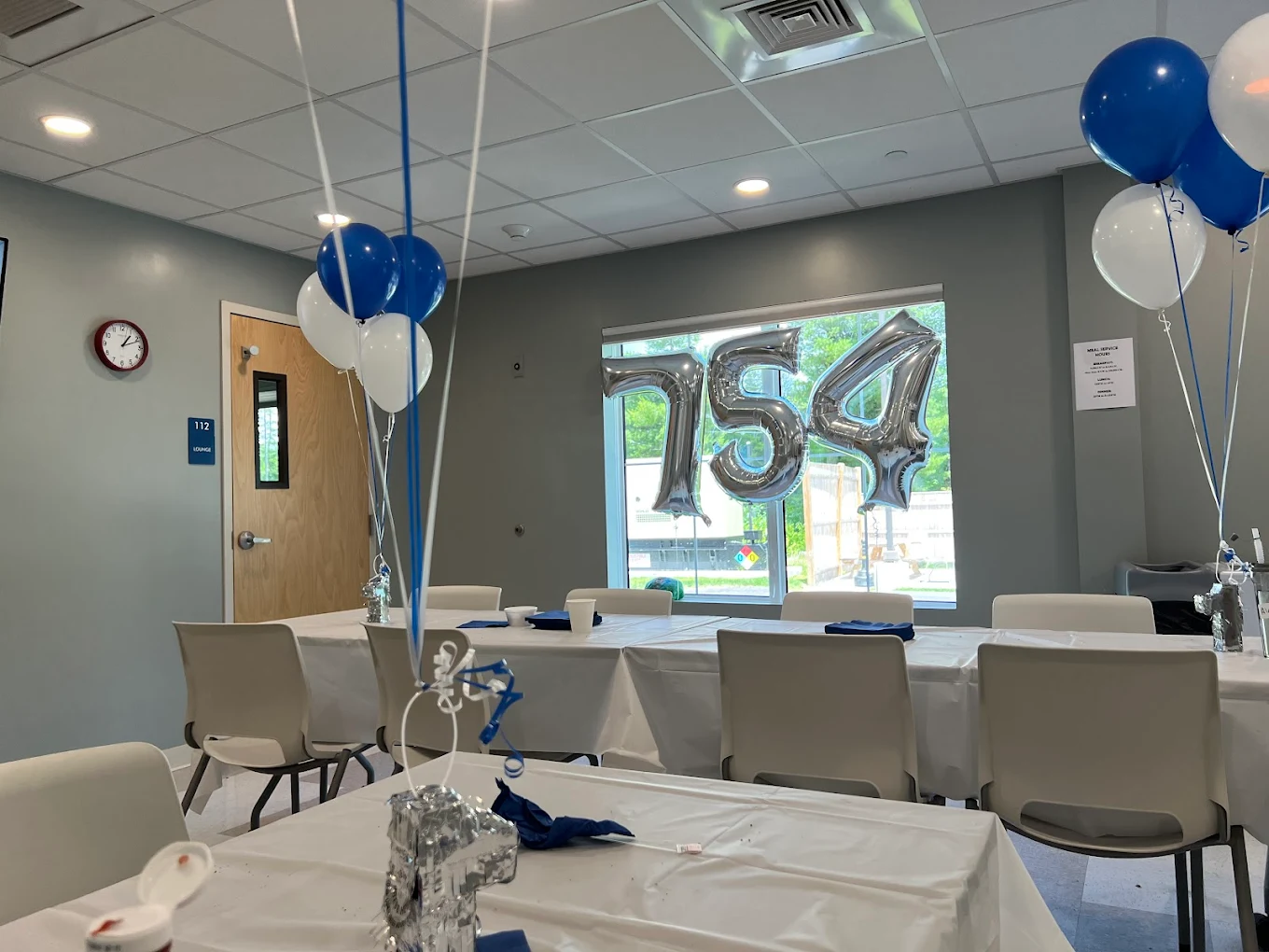 Decorated room with balloons and tables set for event