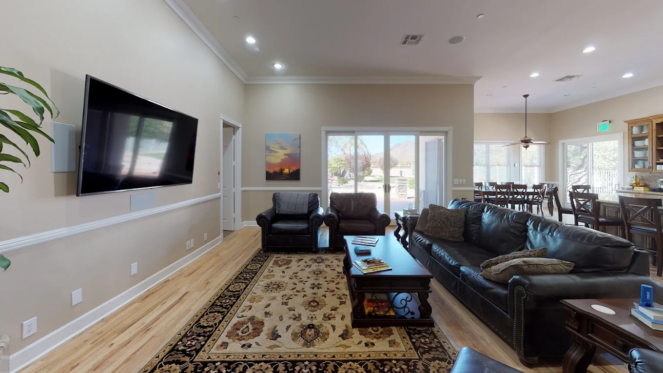 Living room with leather seating, television, and dining area