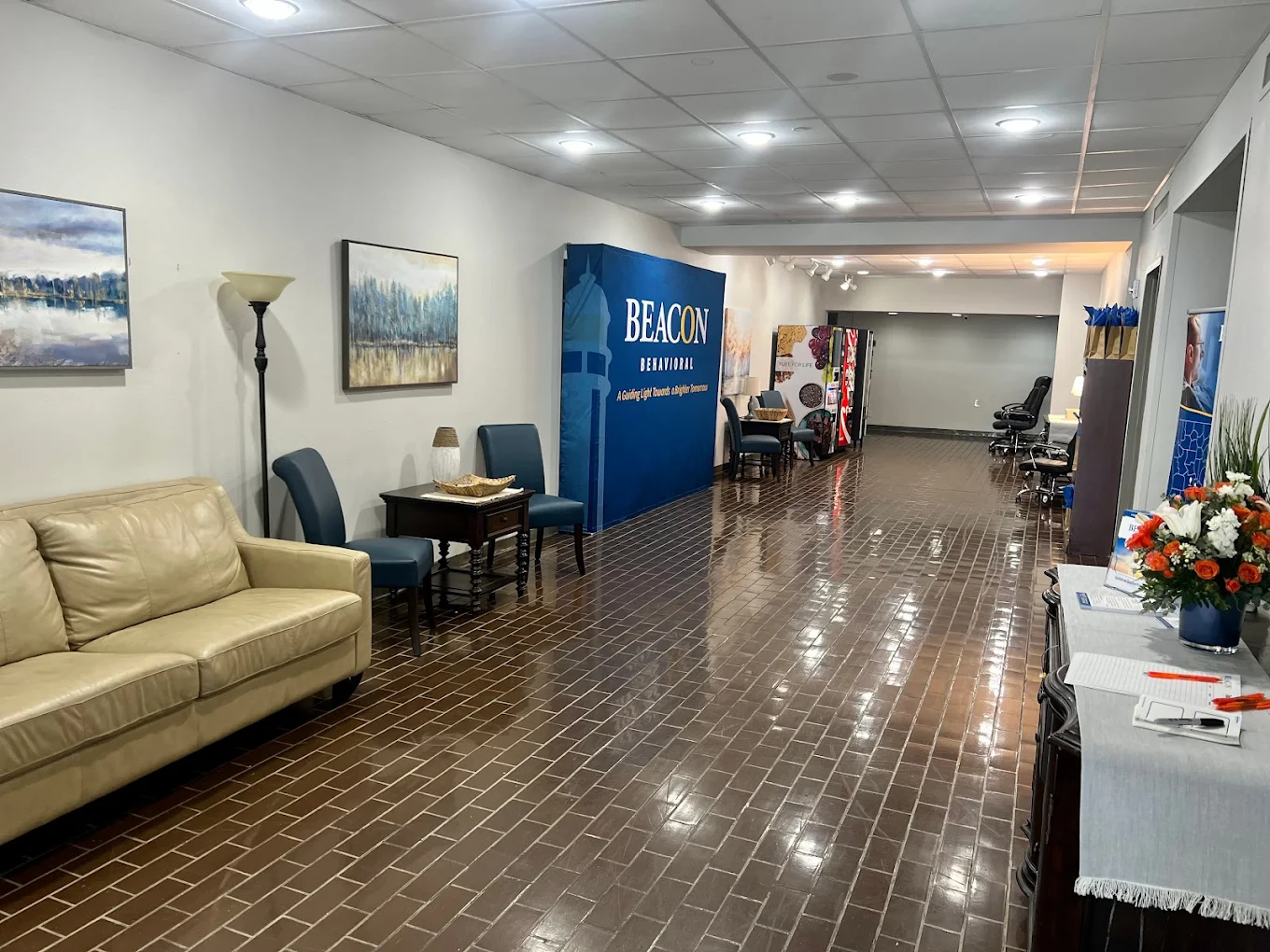 Long hallway with seating, decor, and vending machines