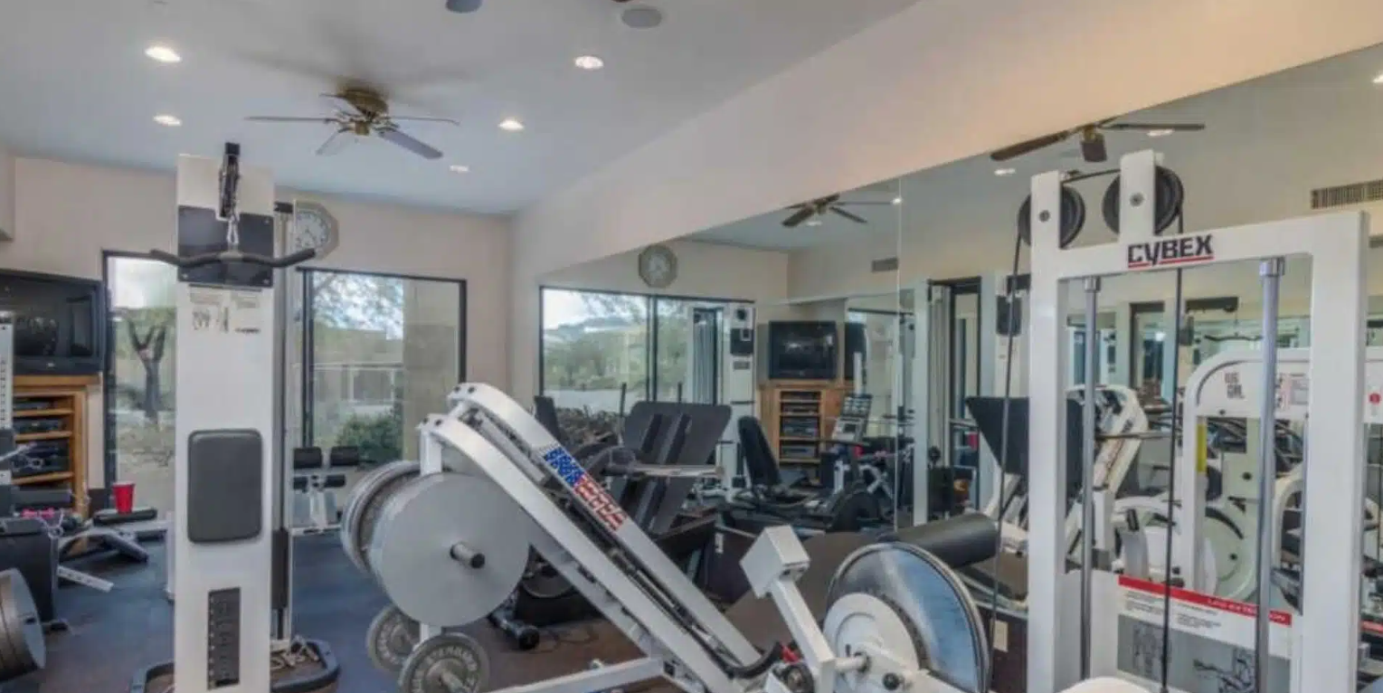 Gym with exercise machines and large wall mirrors