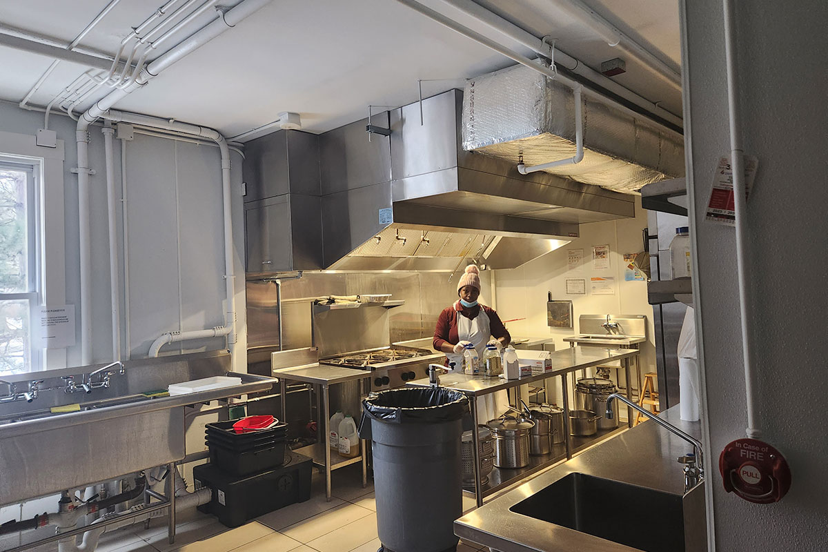 Woman in commercial kitchen with stainless equipment
