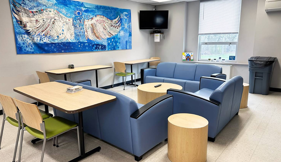 Group lounge with seating, tables, and wall-mounted TV