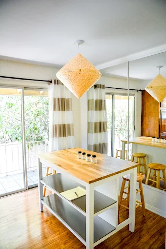 Bright dining nook with island table, stools, and pendant lights