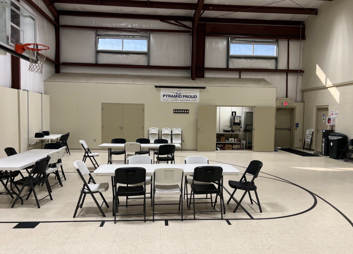 Multi-use gym with folding tables and basketball hoop