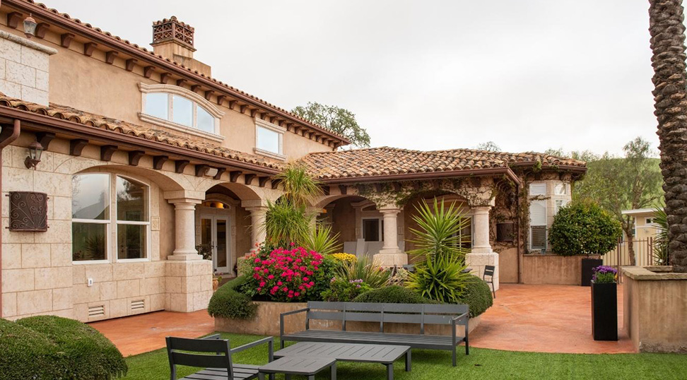 Spacious patio with landscaping, benches, and a tiled exterior.