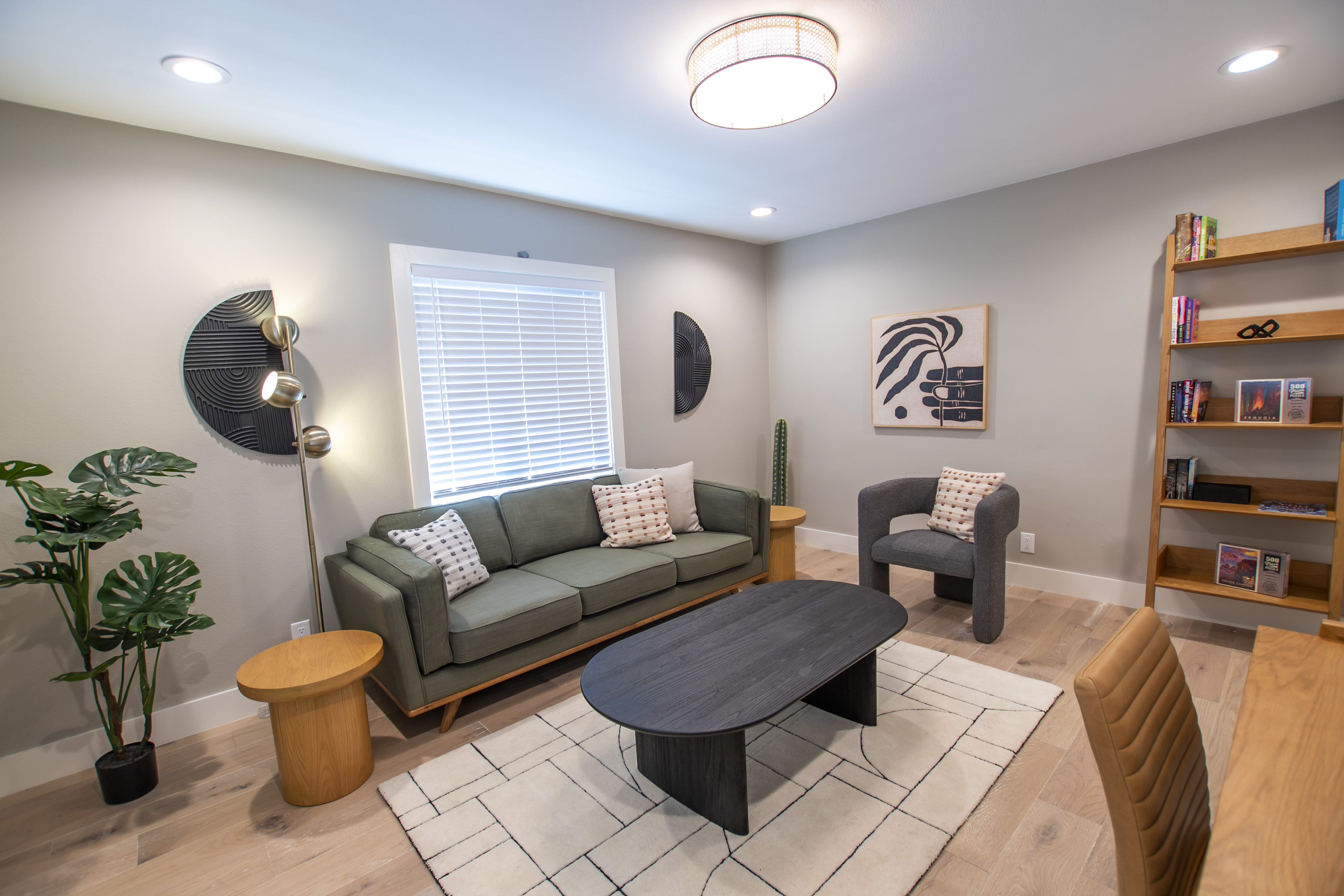Stylish seating area with a green sofa, bookshelves, and artwork