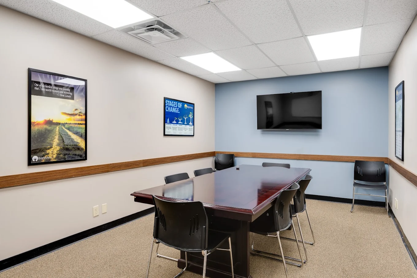Group room with large table, chairs, and wall-mounted TV