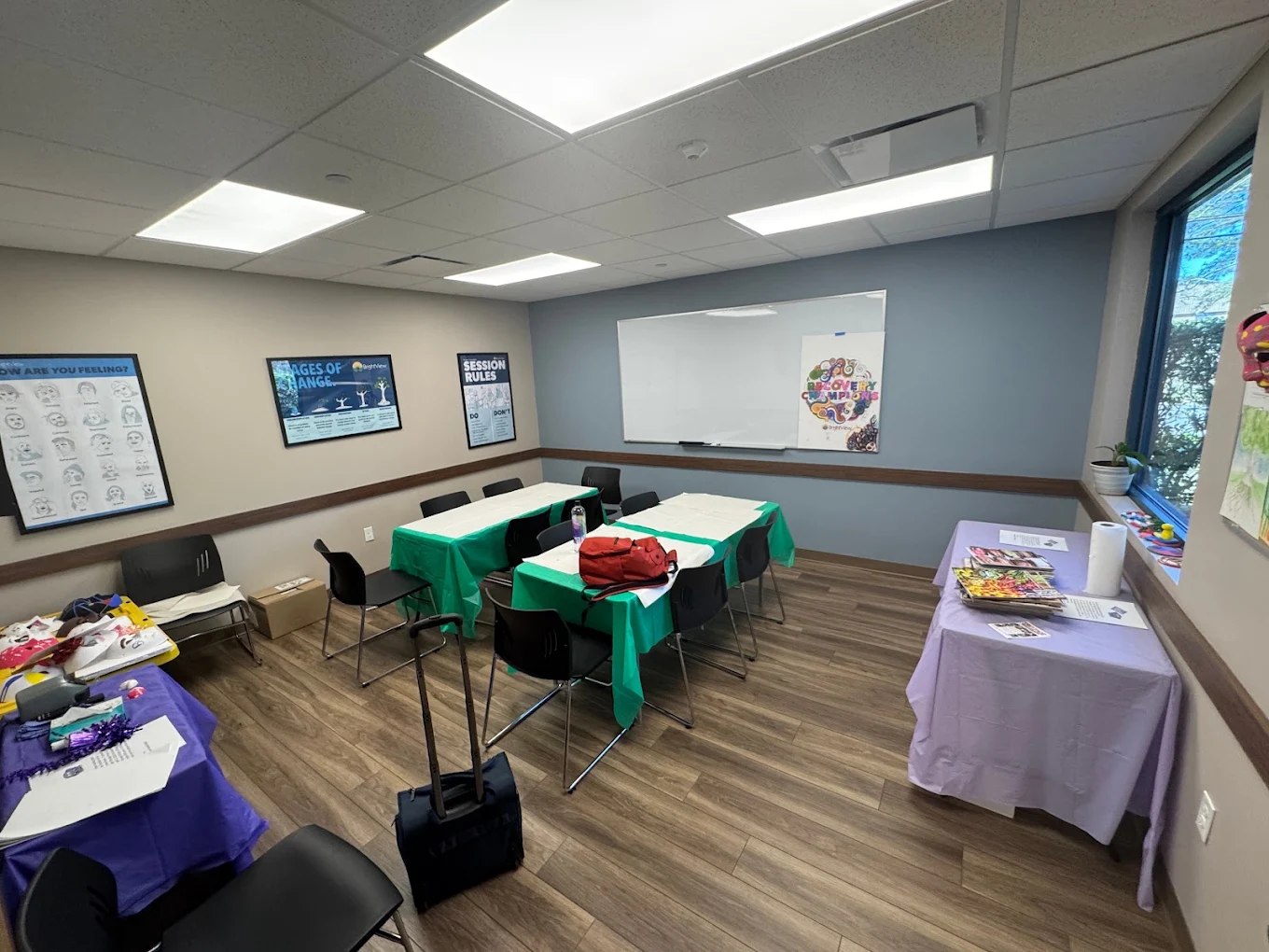 Group therapy room with tables, chairs, and whiteboard
