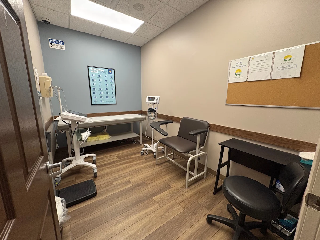 Clinical room with exam table, medical equipment, and patient chair