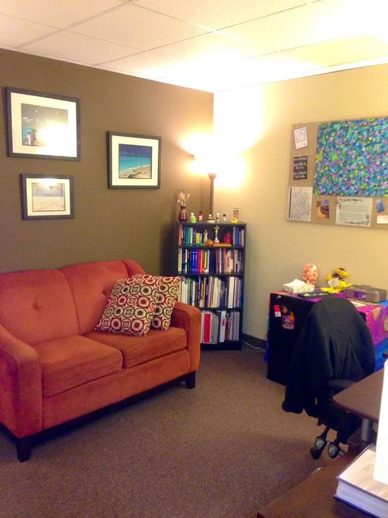 Private counseling office with sofa and resource bookshelf